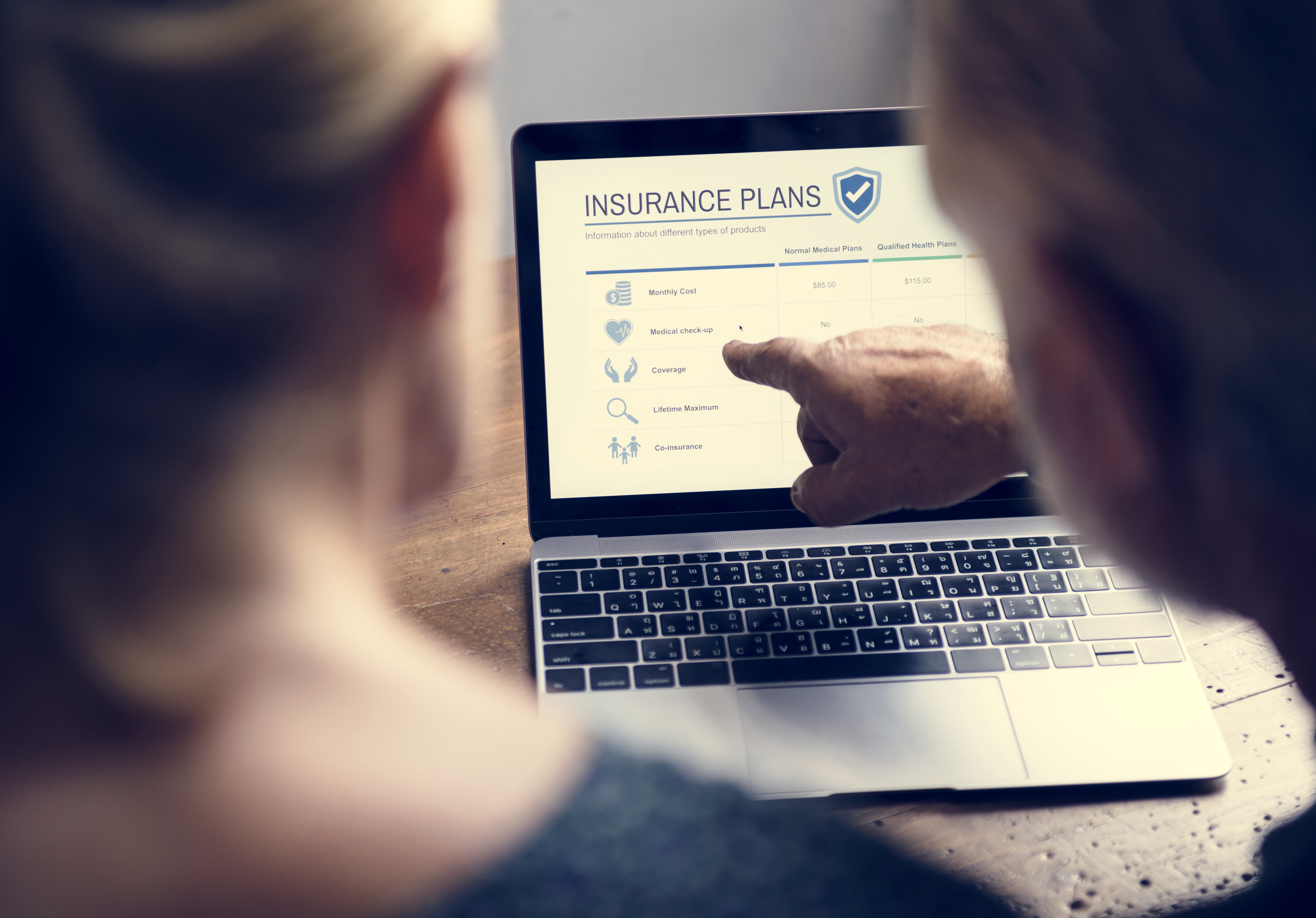 Two people looking at a life insurance plan on a laptop