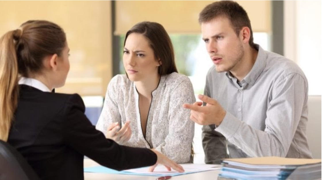 Insurance producer talking to a man and woman who look concerned